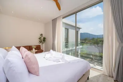 a bedroom with a white bed and a large window at Duplex 5 & 4 BR Private Pool Villa - Laguna Phuket in Laguna Phuket