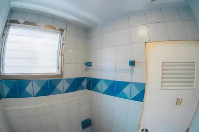 a bathroom with blue and white tiles and a window at XX Mitr Inn Phuket Mueang Kao - มิตร อินน์ ภูเก็ต โอลทาวน์ in Phuket Town