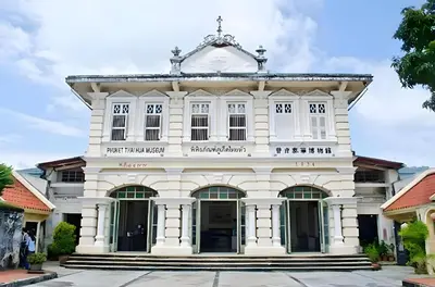 an old white building in a street at XX Mitr Inn Phuket Mueang Kao - มิตร อินน์ ภูเก็ต โอลทาวน์ in Phuket Town