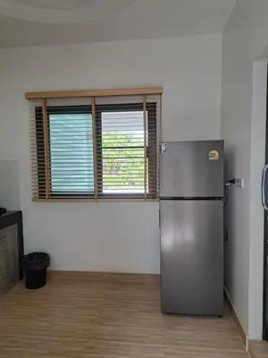 a kitchen with a refrigerator and two windows at Bancha white house in Ban Bo Han
