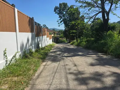 an empty road next to a fence at Kathu V pool villa soi Srikor in Ban Kathu