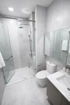 a bathroom with a shower and a toilet and a sink at 2BR Apartment, 10-Min Walk to the Beach in Laguna Phuket