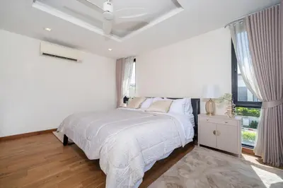a white bedroom with a bed and a window at Lux Laguna Park 5 bedroom rooftop pool in Laguna Phuket