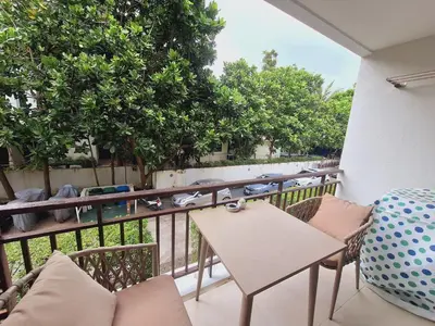a balcony with a table and chairs and a view of a street at The title Aparthotel by Perfect Rawai Holiday Homes in Rawai Beach