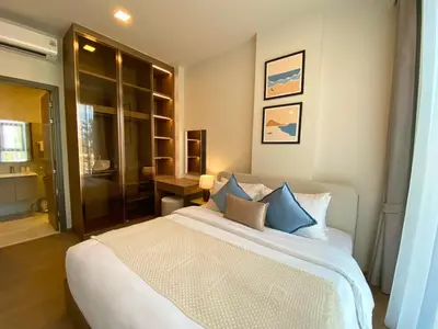a bedroom with a large white bed with blue pillows at New 2 Br Apartment Cherng talay in Laguna Phuket