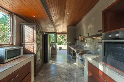 a large kitchen with wooden ceilings and wooden counters at Peaceful Retreat at Villa Langkah Luan, Mai Khao in Mai Khao Beach