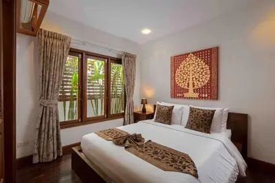 a bedroom with a large white bed and windows at Sea Breeze Pool Villa on Quiet Kamala Cul de sac in Kamala Beach