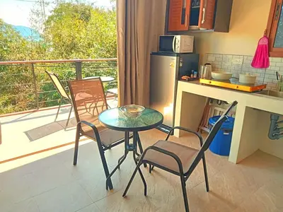 a kitchen with a table and chairs and a balcony at Jasmine Ocean View Penthouse in Ban Saiyuan (1)