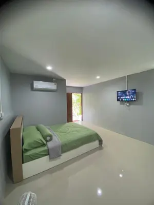 a bedroom with a green bed and a tv at Villakrabi center in Klong Muang Beach