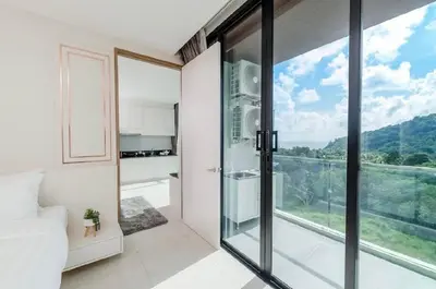 a bedroom with a glass door leading to a balcony at The Viva Patong Condo in Patong Beach