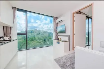 a white room with a large window and a white couch at The Viva Patong Condo in Patong Beach