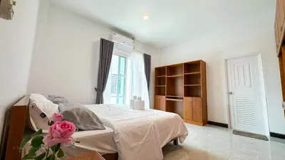 a bedroom with a bed with a pink flower on it at Soulful Stay Phuket l Phanason Park Ville 1 Near Kathu Waterfall in Ban Kathu
