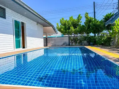 a swimming pool in front of a house at Soulful Stay Phuket l Phanason Park Ville 1 Near Kathu Waterfall in Ban Kathu