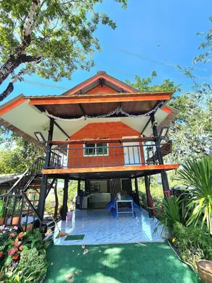 a house with a large roof on top of a yard at Raya villa in Ban Muang Mai