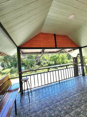 a pavilion with a bench and a view of the forest at Raya villa in Ban Muang Mai