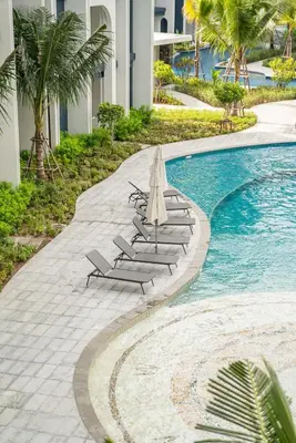 a swimming pool with lounge chairs and an umbrella at Title Halo Pinky Lime Naiyang Pool Gym Hammam in Ban Bo Han