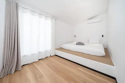 a bedroom with a bed and a large window at wolin patong greeen resort in Patong Beach
