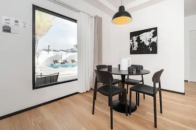 a dining room with a table and chairs and a window at wolin patong greeen resort in Patong Beach