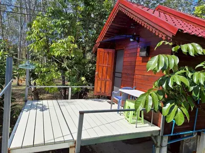 a small cabin with a wooden deck and a door at Meesaeng Homestay in Thalang