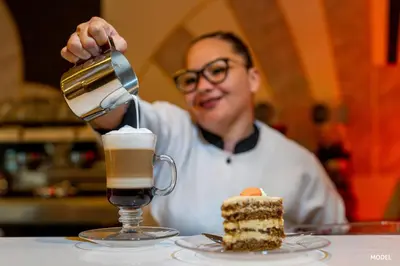 a man is pouring coffee into a drink at Hotel Riu Palace Phuket - All Inclusive in Mai Khao Beach