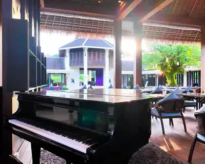 a piano in a room with a table and chairs at BB Luxury Villa in Phuket Town