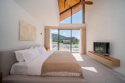 a bedroom with a large bed and a tv at \u9760\u8fd1\u5e2e\u6d9b\u6d77\u6ee9\u56db\u5367\u5ba4\u5bb6\u5ead\u522b\u5885 in Ban Lum Fuang