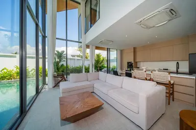a living room with a white couch and a kitchen at \u9760\u8fd1\u5e2e\u6d9b\u6d77\u6ee9\u56db\u5367\u5ba4\u5bb6\u5ead\u522b\u5885 in Ban Lum Fuang