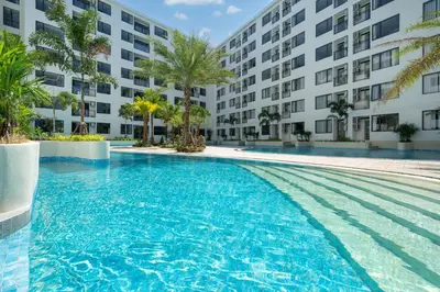 a swimming pool in front of a building at Capri Residence Bangtao in Ban Thalat Choeng Thale