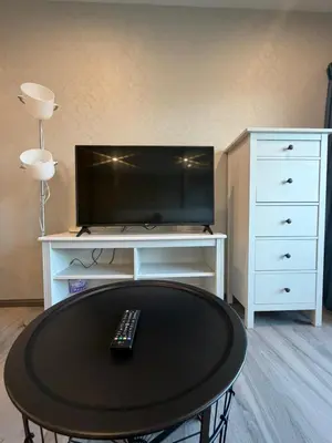 a living room with a tv and a table with a remote control at 1 BDR 5 Swimming Pool Entire Apt Complex 5 Mins WALK To Naiyang Beach in Phuket