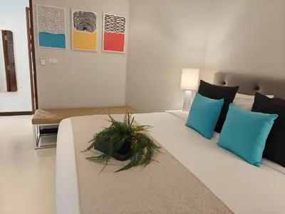a bedroom with a bed with a plant on it at Dewa 1302 Poolside Resort Spacious 2 Bedroom in Phuket Town