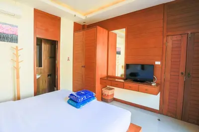 a bedroom with a white bed and a television at 2 bedroom pool villa 250m TO Rawai beach A5 in Rawai Beach