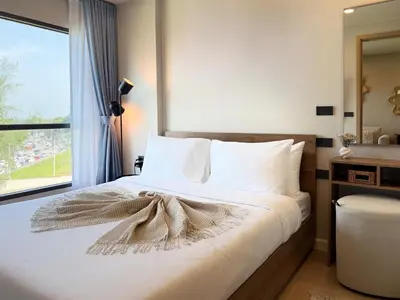 a bedroom with a bed with a bow on it at Gloria's Laguna Nest in Ban Thalat Choeng Thale