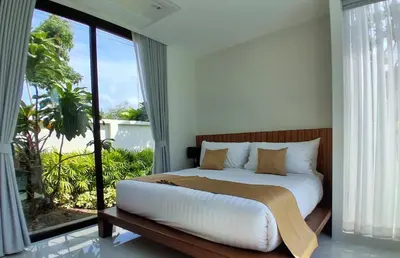 a bedroom with a bed and a large window at Andara Ao Nang Pool Villa in Ao Nang Beach