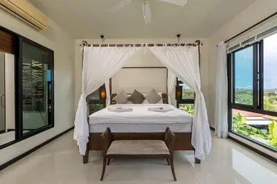 a bedroom with a bed with a canopy and large windows at Ao Yon- Contemporary 3-bedroom private pool villa in Ban Ao Makham