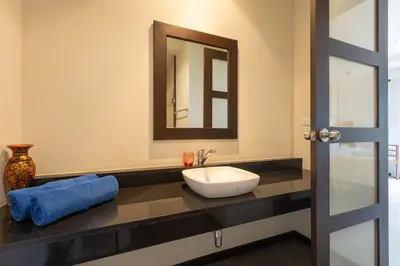 a bathroom with a sink and a mirror at Ao Yon- Contemporary 3-bedroom private pool villa in Ban Ao Makham