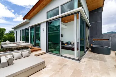 a glass house with a tub in a patio at Absolute Beachfront Villa 3-Bedroom in Rawai in Ban Saiyuan (1)