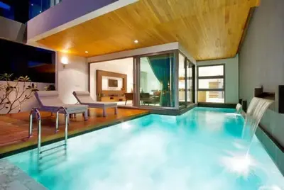 a large swimming pool with two chairs and a table at Absolute Beachfront Villa 3-Bedroom in Rawai in Ban Saiyuan (1)