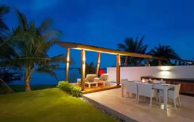 a house with a table and chairs on a patio at Absolute Beachfront Villa 3-Bedroom in Rawai in Ban Saiyuan (1)