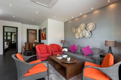 a living room with red chairs and a couch at 2-Bed Pool Villa Chalong-Bright Modern & Relaxing in Ban Suan