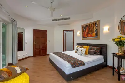 a bedroom with a large bed and a couch at Peaceful 2-Bedroom Villa on Loch Palm Golf Course in Ban Kathu