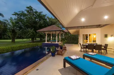 a house with a swimming pool and a patio at Peaceful 2-Bedroom Villa on Loch Palm Golf Course in Ban Kathu