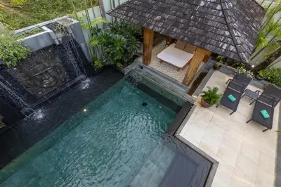 an overhead view of a swimming pool with chairs and an umbrella at Diamond Tree Escape Pool Villa in Bangtao in Ban Pak Lak