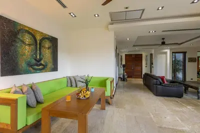 a living room with a green couch and a table at Diamond Tree Escape Pool Villa in Bangtao in Ban Pak Lak