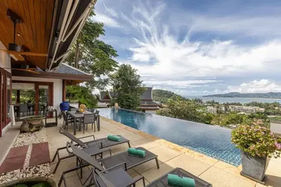 a house with a swimming pool and a patio with chairs at Villa Elan Luxury Surin Villa Panoramic Sea Views in Surin Beach