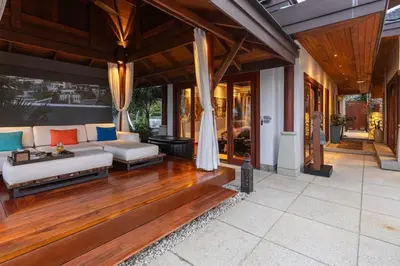 an outdoor living room with a couch and wooden floors at Villa Elan Luxury Surin Villa Panoramic Sea Views in Surin Beach