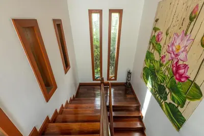 a staircase in a house with a painting on the wall at Villa Elan Luxury Surin Villa Panoramic Sea Views in Surin Beach