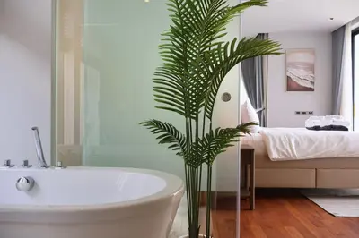 a bathroom with a bath tub and a palm tree at Botanica - Bali Style Luxury 3 BR Private Pool Villa in Ban Pak Lak