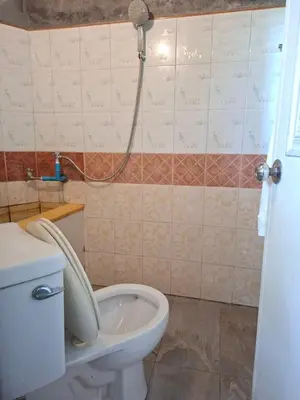 a bathroom with a toilet with the lid up at Budget Place Homestay-Solo Traveler in Ban Dan