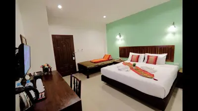 a bedroom with a bed and a table and a desk at BS Airport at Phuket in Nai Yang Beach