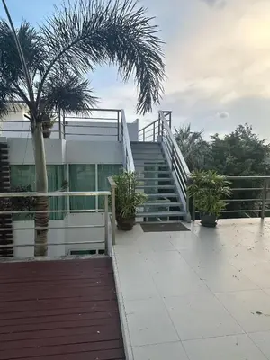 a building with stairs and palm trees in front of it at Comfort SeaView Apartment with Private Plunge Pool in Patong Beach